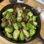 savory brussels sprouts in cast iron pan with bacon, onions, and garlic