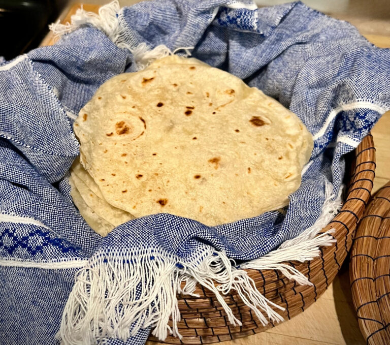 fresh milled flour tortillas in basket with blue towel