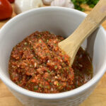 fresh salsa in bowl with wooden spoon