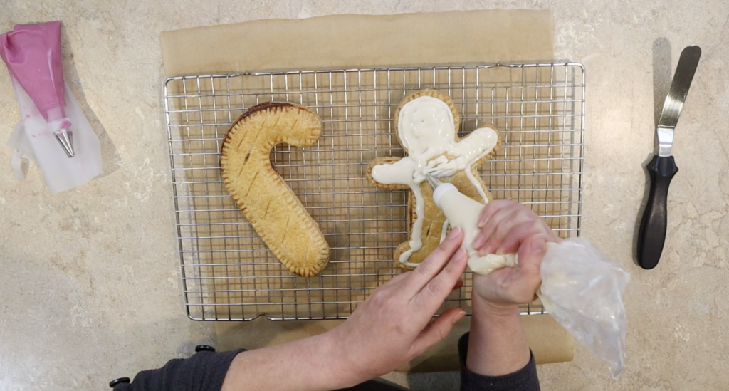 Icing holiday hand pies made with fresh milled flour.